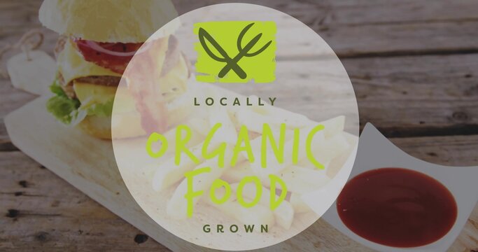 Displaying organic badge covering beef burger and fries on rustic table, with square ketchup dish