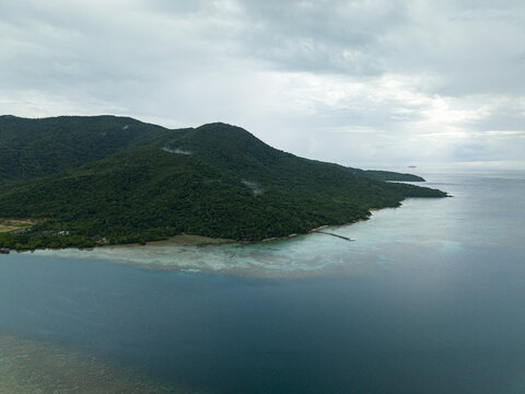 Aerial view of the lush, green island meeting the turquoise sea, a tranquil scene of natural beauty at Turtle Conservation, Karimunjawa, Central Java, Indonesia.