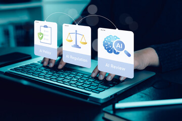 Businesswoman using laptop with AI policy, AI regulation, and AI review interface, representing responsible AI governance, compliance, legal oversight, and ethical technology management.