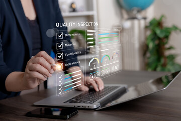 Businesswoman using laptop with digital quality inspection dashboard, checklist, and performance metrics for product evaluation, process control, and compliance monitoring.