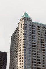 Fototapeta premium Tall building with a green roof in an urban area showing modern architecture