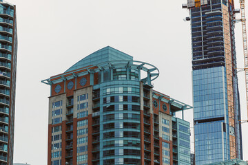 Fototapeta premium Skyscrapers rise above the city skyline during a cloudy day in a bustling urban area