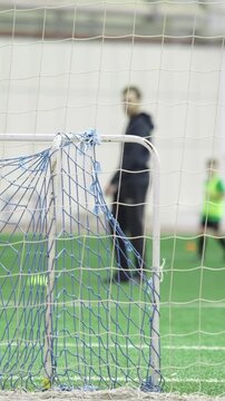 Children training and scoring a goal in indoor soccer practice