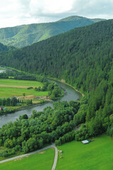 Naklejka premium Aerial view of river in green valley