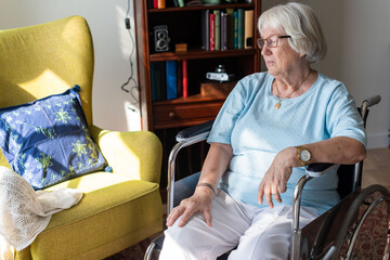 Obraz premium Elderly woman in wheelchair indoors.