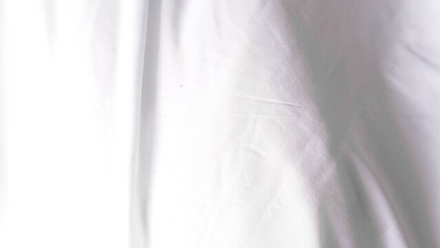White fabric texture with soft folds and creases in natural light