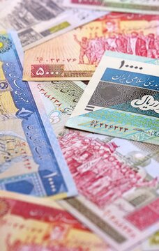 Iranian rial money bills pile on table. Iran banknotes of IRR currency close up.
