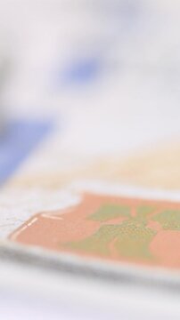 Closeup dollar bills falling softly across tabletop, treasurer counts edges in slow motion, macro focus reveals security threads, printed texture and layered paper, muted white