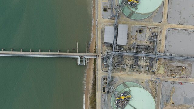 Aerial view of the industrial port where the sea meets the shore, tanks, and pipelines stretch out, Map Ta Phut, Rayong, Thailand.