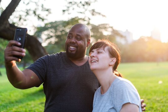 Happy couple taking selfie outdoors.