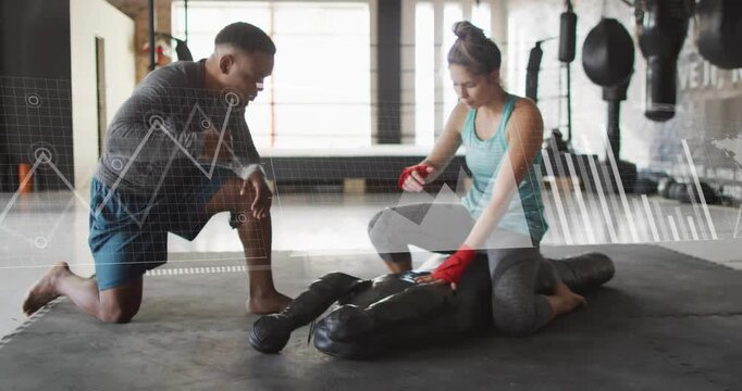 Vertical video: Coach signaling trainee fixing wraps and training bag strikes for fitness, overlays