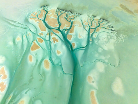 Aerial view of turquoise waterways weave through sandy islands, creating a surreal landscape of contrasting colors and textures, Al Nouf, Abu Dhabi, United Arab Emirates.