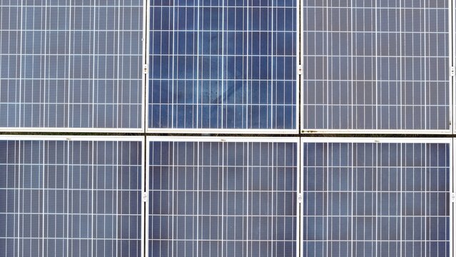 Aerial view of neat rows of solar panels gleam under the sun near the former RAF Alconbury, Huntingdon, Cambridgeshire, United Kingdom.