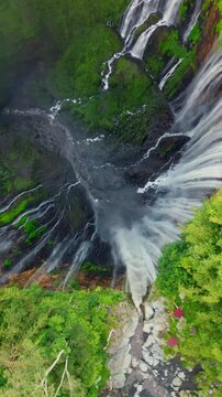 Cinematic aerial top-down of Tumpak Sewu Waterfall &ndash; Majestic circular canyon with multiple falls and tropical jungle in East Java, Indonesia
