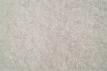 Close-up view of light grey soft fuzzy fabric creates a uniform plush textile texture for comfort. © vannet