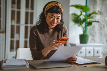 Asian woman scanning document using phone banking application