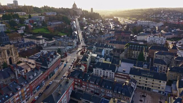 Lisieux cityscape at sunset, with the Basilica of Sainte-Th&eacute;r&egrave;se on the hill in the background, Normandy, France. Aerial forward