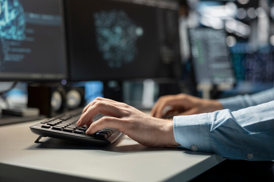 Close up of data center technician coding on PC to update server tech, configuring equipment using software tools. Server room employee types on computer keyboard, ensuring reliable network operations
