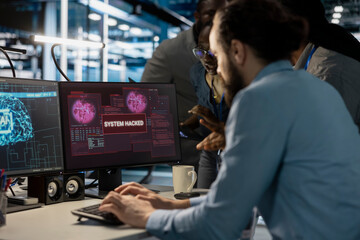 Close up of data center admins reacting to virus alert on PC monitor, initiating protocol to protect critical systems. Server room coworkers review hacking attempts and assessing compromised gear