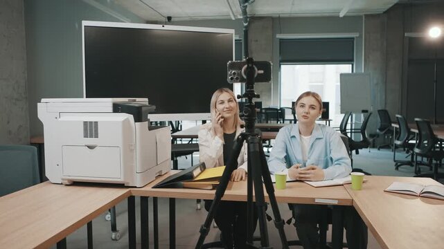 Business meeting with man and woman discussing project plans in an office setting with camera recording