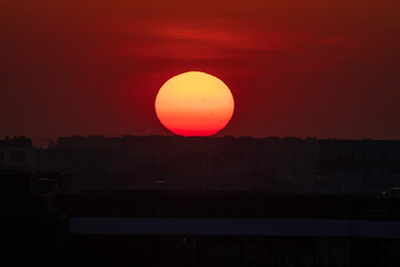 Czerwony zachód słońca nad polskim miastem, sylwetki budynków na tle nieba © smoku7979