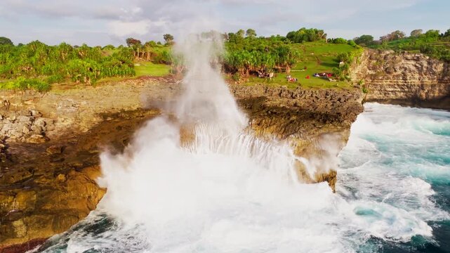 Cinematic aerial top-down of Devil's Billabong &ndash; Powerful ocean waves crashing into rocky tide pools and limestone cliffs in Nusa Penida, Bali