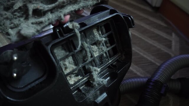 A dirty vacuum cleaner filter clogged with dust and hair. Concept of cleaning and allergies.