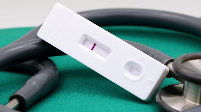 A high-angle, close-up shot of a white plastic pregnancy test cassette displaying only one distinct red line, signifying a negative result. 