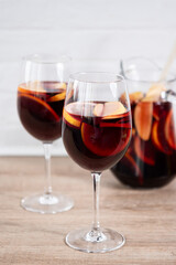 Sangria cocktail with fresh fruit on wooden table and white background