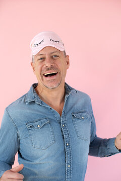 man with pink sleep mask in front of pink background