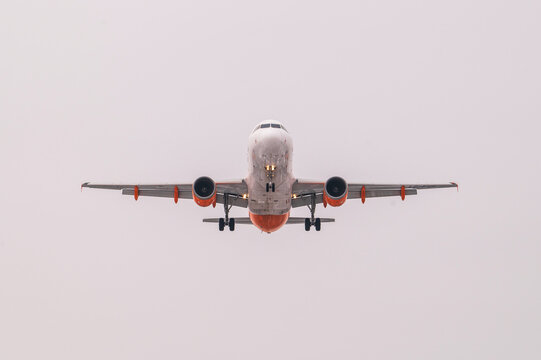 Samolot pasażerski podchodzący do lądowania, widok od przodu na tle nieba, transport lotniczy
