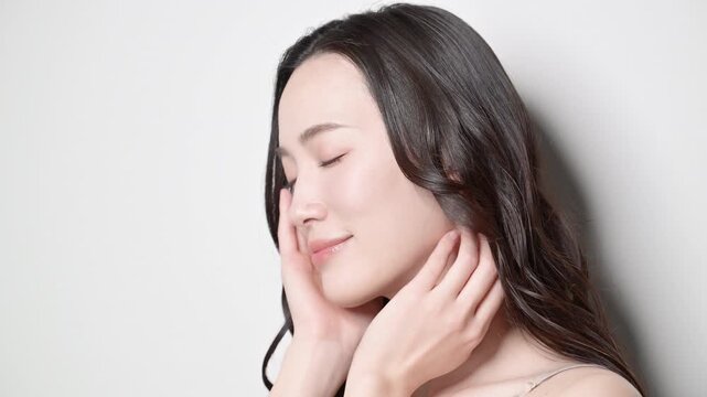 黒髪が綺麗で若い女性の艶や透明感のあるビューティーイメージ　見上げる目を閉じるうっとりする美しいアジア人女性の動画