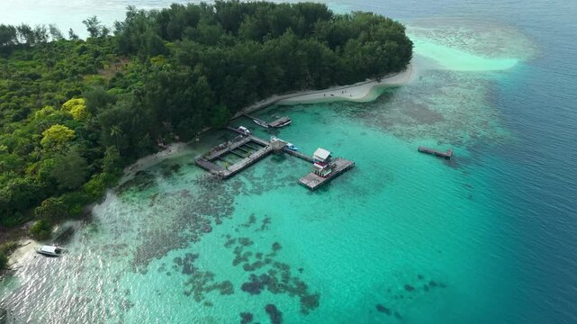 Aerial view of Shark Breeding with a lush green island fringed by turquoise waters contrasting with the deep blue sea, a serene tropical paradise, Karimunjawa, Jawa Tengah, Indonesia.