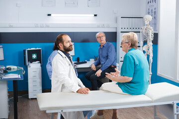 Obraz premium Elder woman consults with chiropractor for back pain. Senior patient receives medical help and therapy for physical recovery. The hospital offers physiotherapy exercises and rehabilitation.