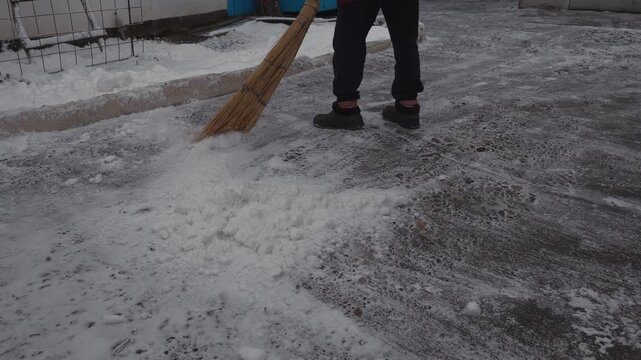 Village sketches, snow removal with a broom, winter, frost, private house yard