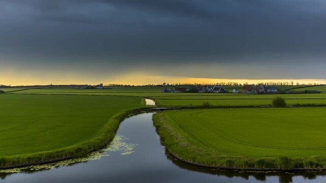 Dramatic storm clouds gather over a picturesque Dutch polder landscape