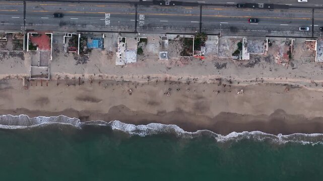Aerial view of the beach showing sandy shoreline, remnants of buildings, and the Pacific Coast Highway running parallel, Malibu, California, United States.