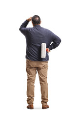 Naklejka premium Rear view of a man holding a paint roller and thinking