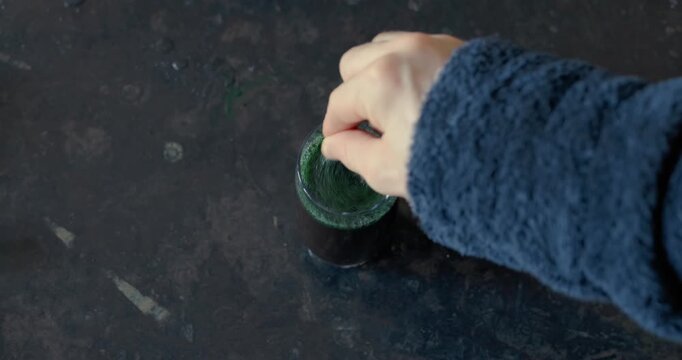 Mixing a spirulina beverage in the glass, top view, audio included