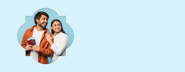 A couple stands close together, holding passports and smiling. They show excitement for their upcoming travel. The backdrop is light blue, enhancing their joyful expressions. © Prostock-studio