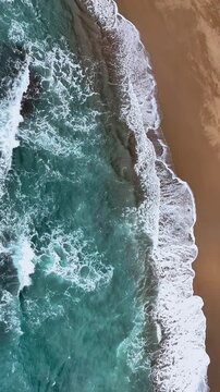 Aerial view of the sandy beach meeting the turquoise ocean with foamy white waves crashing along the coast, Tambor, Puntarenas Province, Costa Rica.