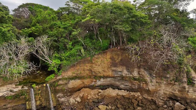 Aerial view of the rugged coastline meets lush forest, contrasting the turquoise sea with the verdant canopy, Tambor, Puntarenas Province, Costa Rica.