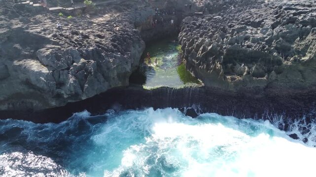 Cinematic aerial drone pulling out revealing dramatic limestone cliffs around Angel&rsquo;s Billabong, Nusa Penida, Indonesia.
