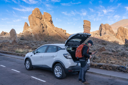 A tourist by a car in Teide National Park. Canary Islands. Tenerife.