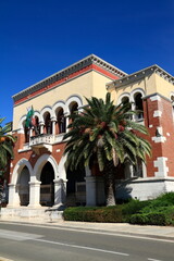 Obraz premium Historic Town Hall Building With Palm Trees And Flags On Mediterranean Facade, Croatia