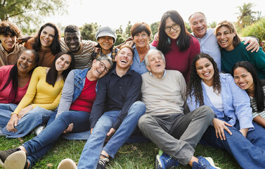 Fototapeta premium Group of multigenerational people smiling in front of camera - Multiracial friends of different ages having fun together - Main focus on senior man face