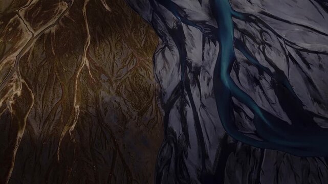 Aerial view of a river delta, channels intertwine through the landscape, creating a mesmerizing contrast of dark earthy tones and vibrant blue water, Iceland.