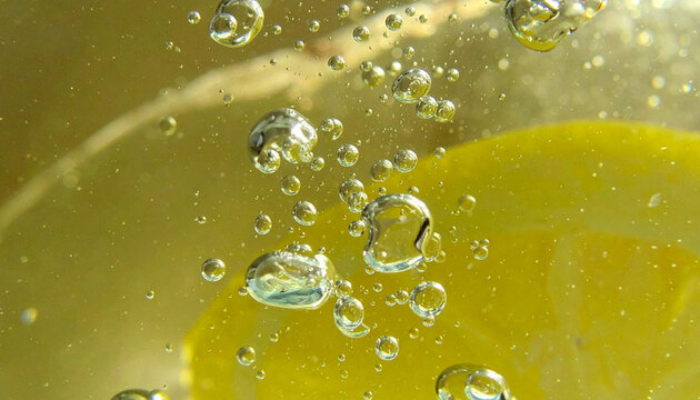 黄色の液体の中に広がる炭酸の泡とボケ　フレッシュで爽快な背景