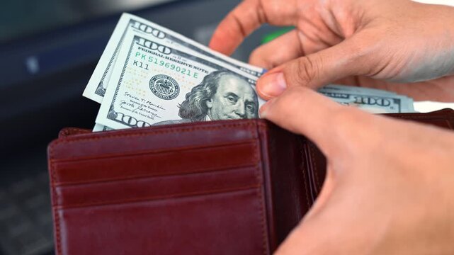 Close up view of woman hands, wallet and American dollar banknotes (USD) in ATM. Concept of saving money for retirement, cash settlement, financial goals, success, literacy and income planning in USA.
