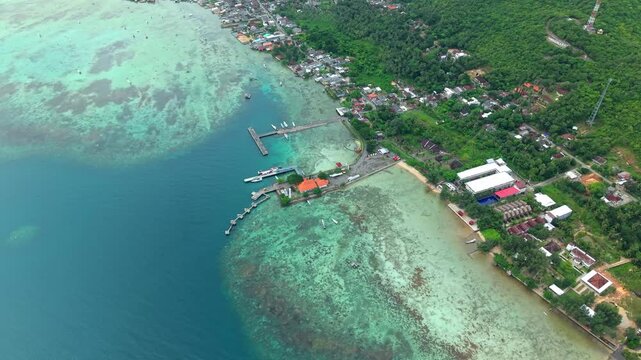 Aerial view of docks and boats in Karimunjawa ferry harbour, where the deep blue sea meets the shore, Karimunjawa, Central Java, Indonesia.